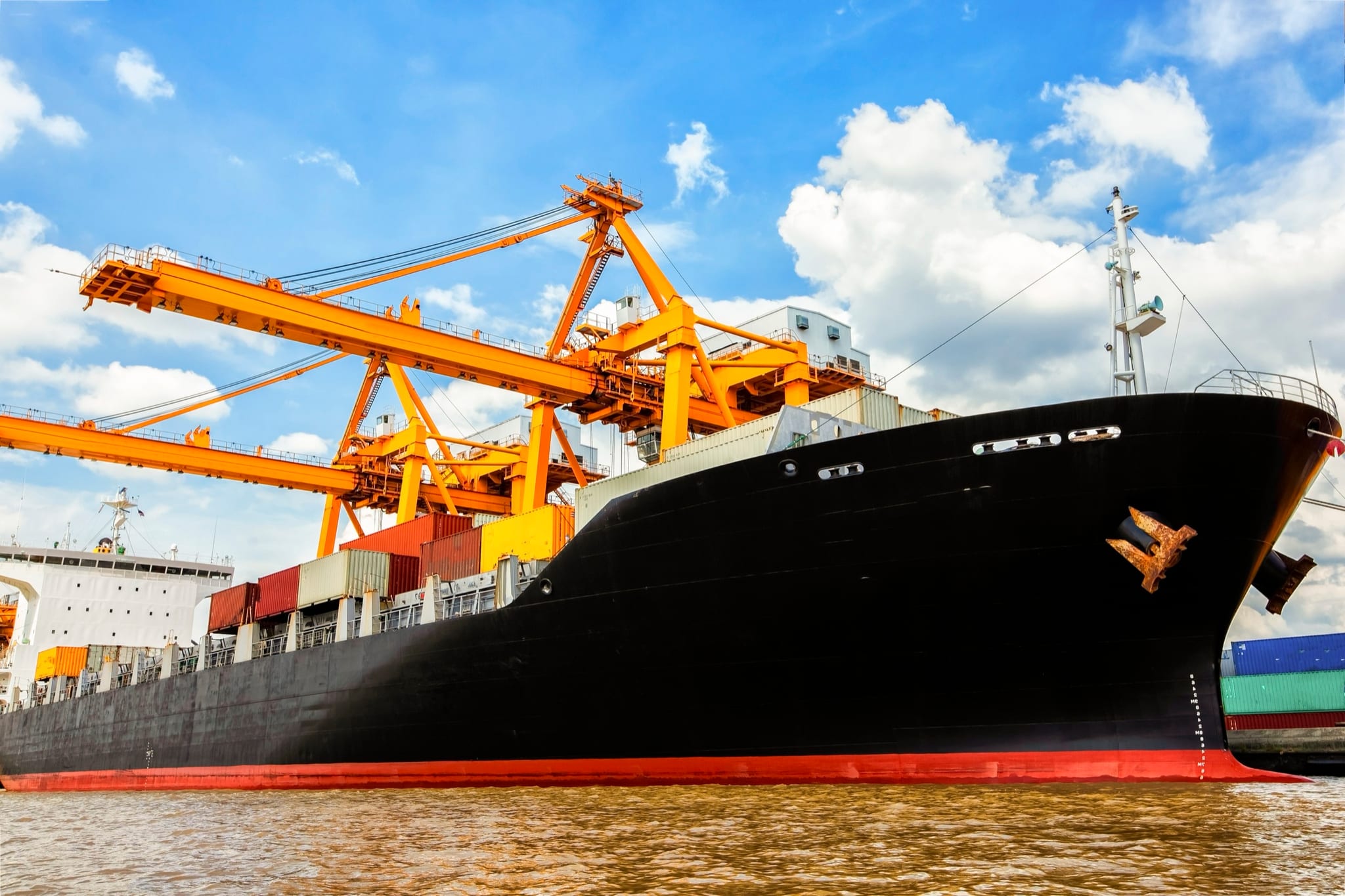 Vrachtschip onder laadkranen in de haven
