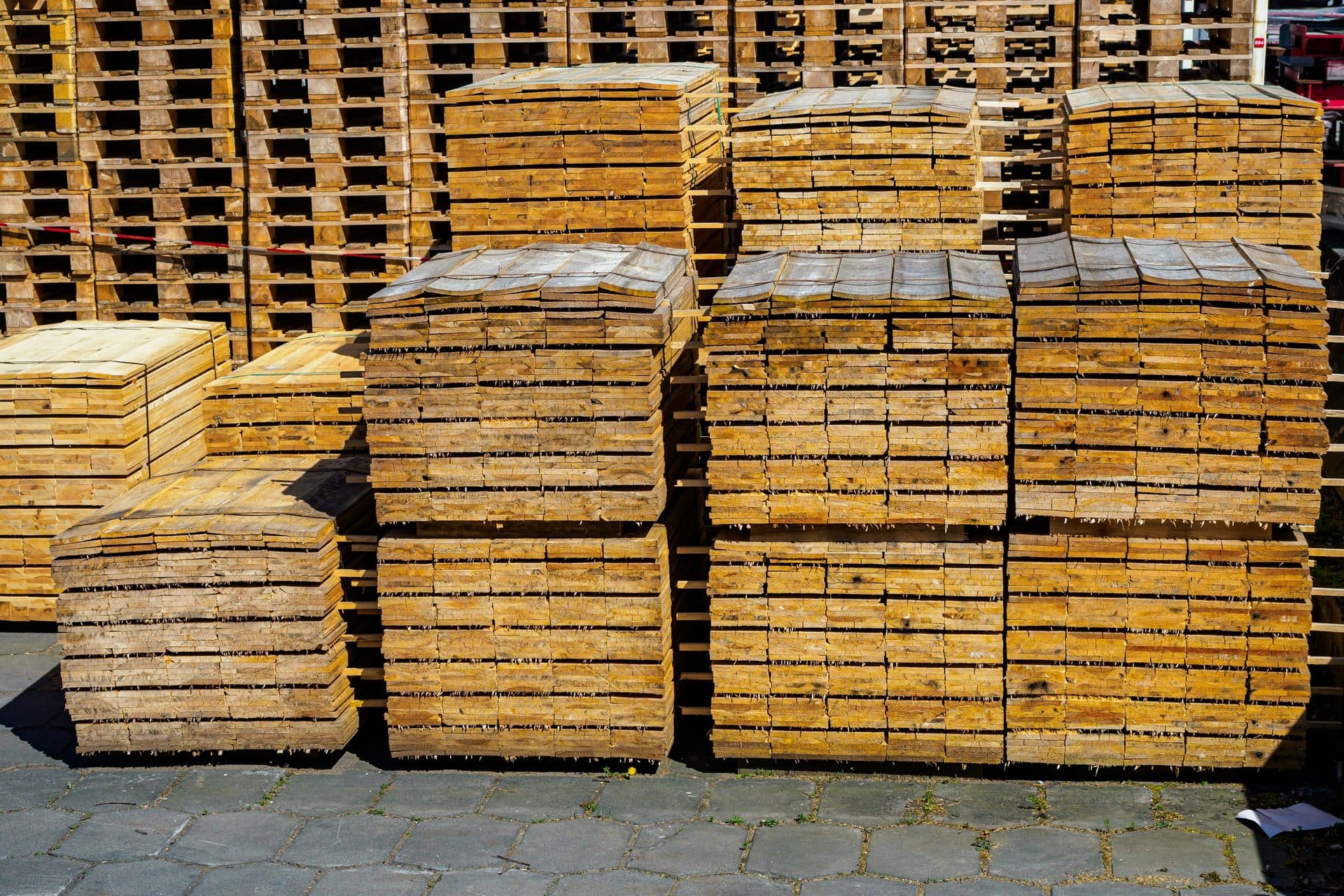 Stapels houten pallets netjes naast elkaar op een buitenterrein