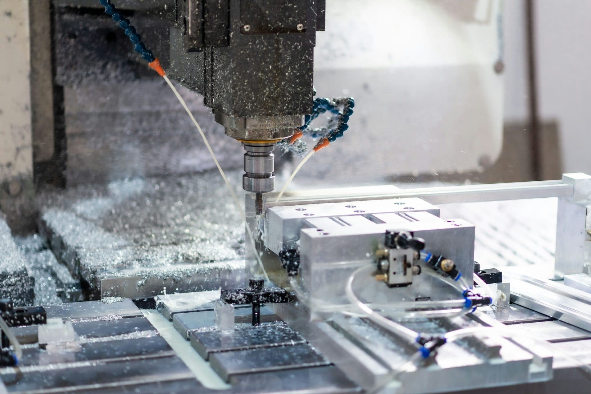CNC freesmachine die een aluminium werkstuk bewerkt met koelvloeistof