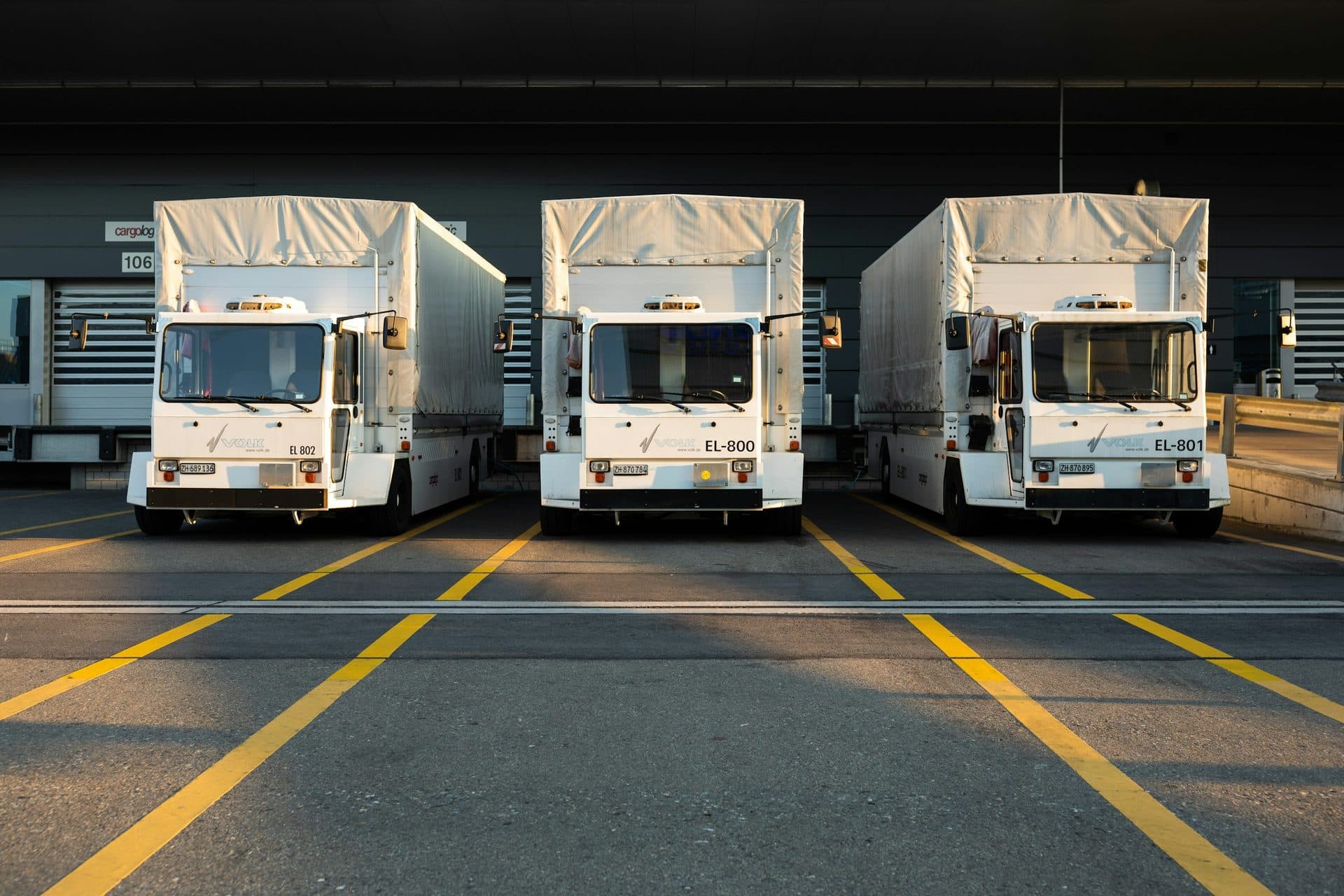 Drie vrachtwagens naast elkaar bij een distributiecentrum
